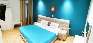 a blue bedroom with a bed with a blue wall at Villa PANGALIS Romantica in Kato Pavliana