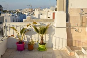 a balcony with three potted plants on a building at Ostuni Guest House in Ostuni