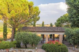 a building with trees and flowers in a yard at Rustico del Conero in Camerano