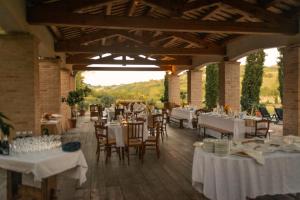 a dining room with white tables and chairs at Rustico del Conero in Camerano