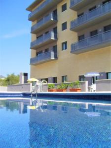 a swimming pool with a slide in front of a building at Apartaments Las Carolinas in Sant Carles de la Ràpita