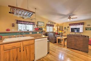 a kitchen with a sink and a living room at Rustic Cabin with Deck about 4 Mi to Old Town Flagstaff! in Flagstaff