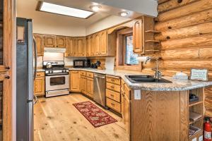 a kitchen with wooden cabinets and a stove top oven at Cabin on Kenai Peninsula Family and Group Friendly! in Kenai
