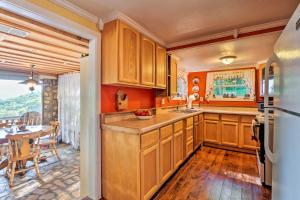 a kitchen with wooden cabinets and a table and a dining room at Mountain Cottage with Views Near Tail of the Dragon! in Fontana Village
