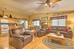a living room with leather furniture and a ceiling fan at Rustic Cabin with Deck about 4 Mi to Old Town Flagstaff! in Flagstaff