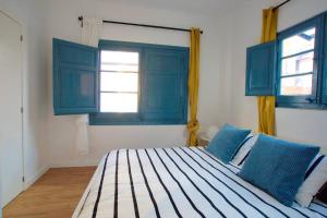 1 dormitorio con ventanas azules y 1 cama grande en LOVELY FLAT FIRA MWC, en Hospitalet de Llobregat
