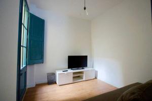 sala de estar con TV en una pared blanca en LOVELY FLAT FIRA MWC, en Hospitalet de Llobregat