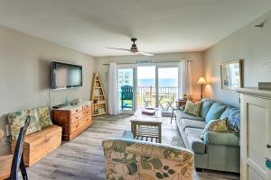 een woonkamer met een bank en een tv bij Airy Oceanfront Condo Beach Views and Pool Access! in North Topsail Beach