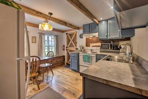 a kitchen with blue cabinets and a table and chairs at Remote 1901 Studio Cabin with Loft - Pets Allowed! in Allenwood