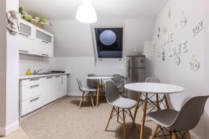 cocina con 2 mesas, sillas y nevera en Willa Doris, en Zakopane