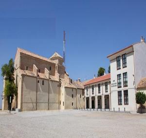 un antiguo edificio con un gran aparcamiento delante de él en Hotel Santuario de Sancho Abarca, en Tauste