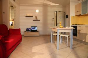 salon ze stołem i czerwoną kanapą w obiekcie Residence Ilario Suite Hotel w mieście Riccione