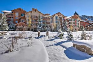 un patio cubierto de nieve frente a un edificio en Solitude Mountain Slopeside Ski Condo with Hot Tub! en Brighton