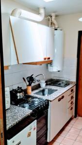 a kitchen with a sink and a stove top oven at Bombal Departamentos in Mendoza