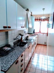 a kitchen with a sink and a stove at Bombal Departamentos in Mendoza