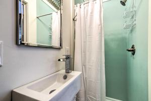 a bathroom with a sink and a shower with a mirror at Walk to Beach from Chic Old Town Apartment with Yard in Bay Saint Louis +16 photos