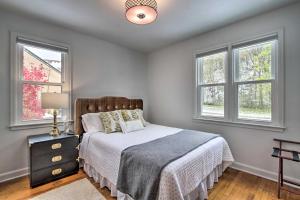 a bedroom with a bed and two windows at Renovated Historic Home Less Than 1 Mile to Eagle Point! in Dubuque