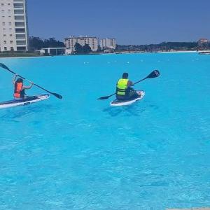 two people in kayaks in the blue water at Laguna Bahia Algarrobo in Algarrobo