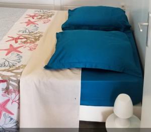 a bed with a blue comforter and pillows on it at Séjournez au coeur des Tropiques Bungalow 2 chambres avec Piscine proche de la mer in Sainte-Anne