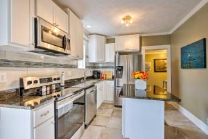 a kitchen with white cabinets and a black counter top at Beachside Getaway - Walk to Gulf, Pier and Casino! in Gulfport