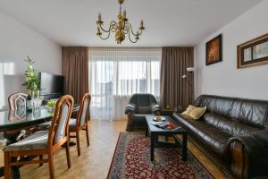 sala de estar con sofá de cuero y mesa en Medicover Wilanow P&O Serviced Apartments, en Varsovia