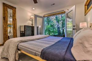 une chambre avec un lit et une grande fenêtre dans l'établissement Boathouse, Sunroom and Decks Lake Lure Cottage, à Lake Lure