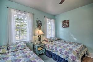 two beds in a room with two windows at Quiet Escape with Hot Tub, 5 Miles to Raystown Lake! in Entriken