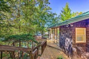 une maison violette avec une terrasse couverte et une terrasse dans l'établissement Boathouse, Sunroom and Decks Lake Lure Cottage, à Lake Lure