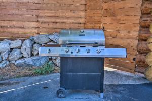 a grill sitting in front of a wooden wall at Custom Bitterroot Valley Cabin with Hot Tub and Views! in Conner