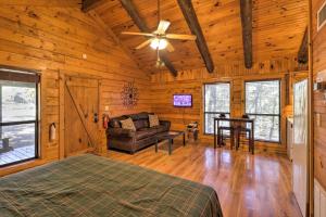 a room with a bed and a couch and a table at Peaceful Cabin 4 Mi to Broken Bow Lake with Hot Tub! in Stephens Gap