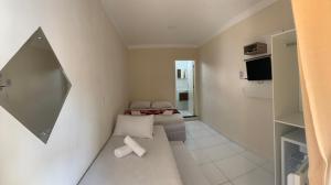 um pequeno quarto com 2 camas e um espelho em Pousada Vitória em Penha
