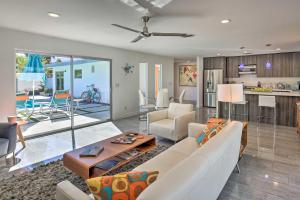 a living room with a white couch and a kitchen at Mid-Century Modern Oasis, 1 Mile to El Paseo! in Palm Desert