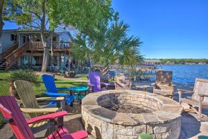 een groep stoelen rond een vuurplaats naast het water bij Dock and Fire Pit Waterfront Cedar Creek Lake Home in Tool