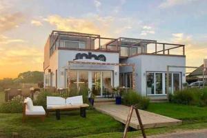 a house with two chairs and a bench in front of it at Depto en Jose Ignacio; gran vista y ubicacion (N) in José Ignacio