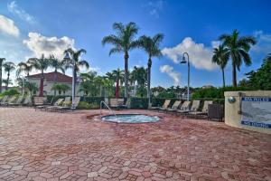 a patio with a fountain with chairs and palm trees at Modern Isla Del Sol Condo Walk to St Pete Beach! in St Petersburg