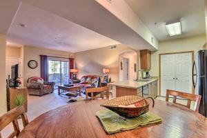 a kitchen and living room with a wooden table at Mesa Condo with Private Patio and Grill Pool Access! in Mesa