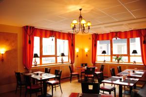 a dining room with tables and chairs and windows at Hotel Kleine Festung Germersheim in Germersheim