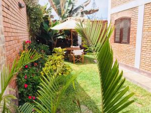 un jardín con mesa y sombrilla en Casa de Playa Arica, en Lurín