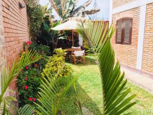 a garden with a table and an umbrella at Hospedaje Casa de Playa Arica in Lurín