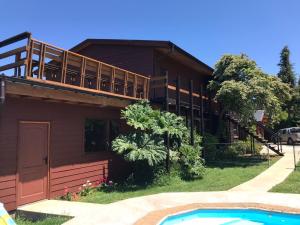 a house with a swimming pool in front of it at Hotel Boutique Cutipay in Valdivia