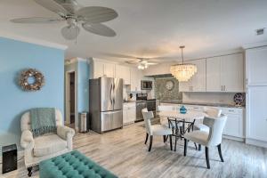 a kitchen and living room with a table and chairs at Breezy Murrells Inlet Condo with Deck Walk to Beach in Myrtle Beach