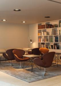a room with tables and chairs and a book shelf at Memmo Alfama - Design Hotels in Lisbon