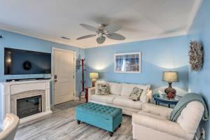 a living room with a couch and a fireplace at Breezy Murrells Inlet Condo with Deck Walk to Beach in Myrtle Beach