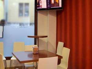 - une salle à manger avec une table, des chaises et une télévision dans l'établissement Hostal Bajo La Muralla, à Zamora