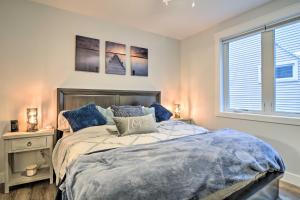 a bedroom with a bed with blue pillows and a window at Modern Michigan Condo about 1 Mi to Grand Traverse Bay in Traverse City