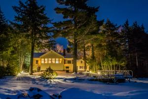 a house in the snow at night at White Lobster Cottage in Greenville