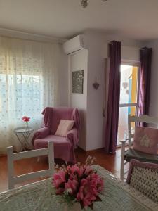 a living room with a pink chair and a couch at Sol y Luz in Isla del Moral
