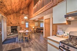 cocina y sala de estar con mesa y sillas en Lakeview Forest Cabin with Deck Less Than half Mile to Beach!, en Madison