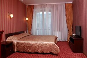 a hotel room with a bed and a window at Hotel Aristokrat in Poltava