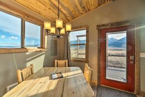 a dining room with a wooden table and windows at Romantic Mountain Getaway - 1 Hour to Yellowstone! in Livingston